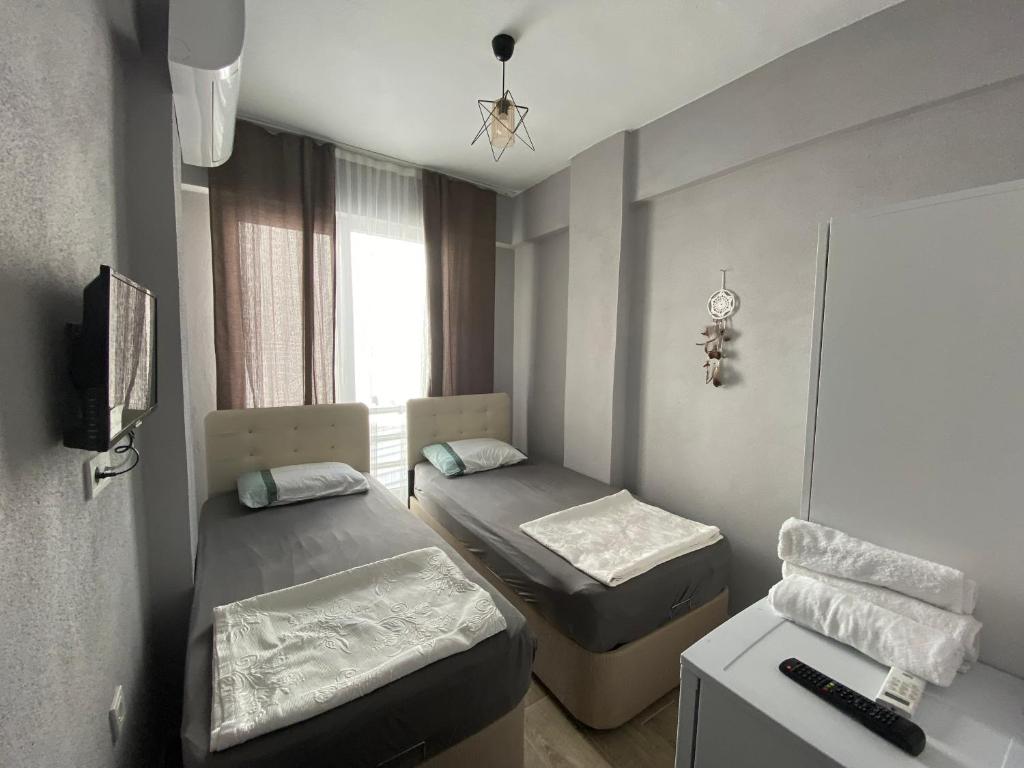 mały pokój z 2 łóżkami i telewizorem w obiekcie Patama Butik Otel w mieście Marmara