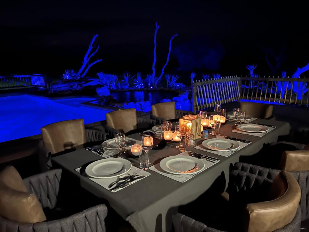 a table with plates and candles on top at Sambane Game Lodge 