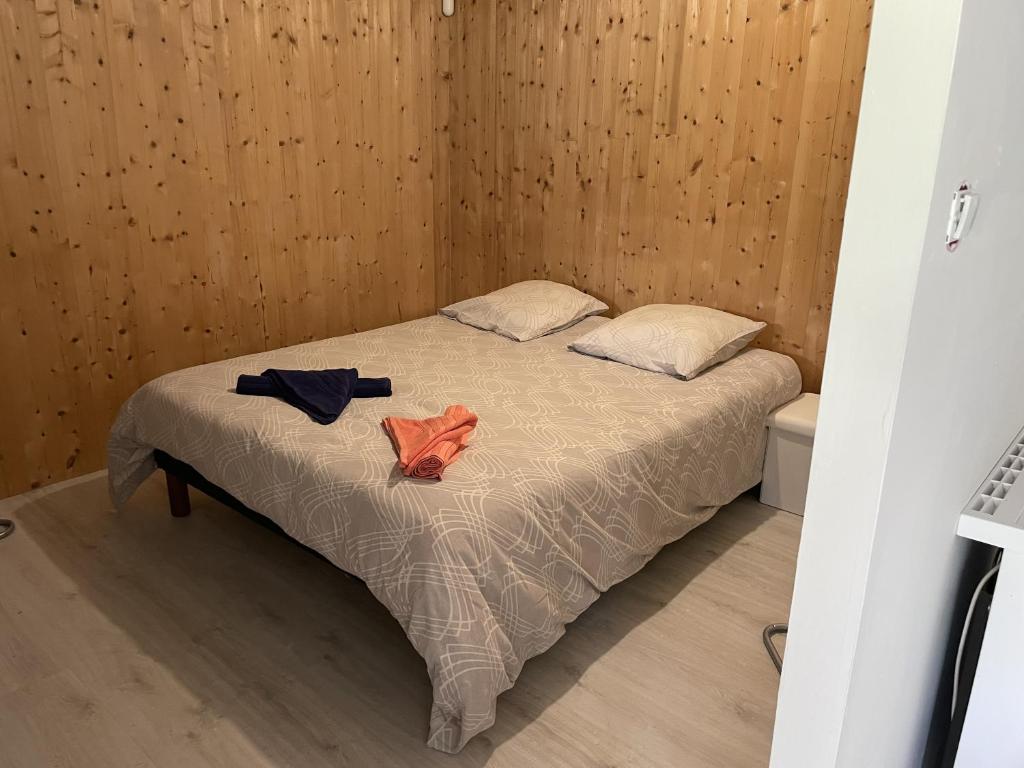Un dormitorio con una cama con dos camisas. en La Pause, en Saint-Martin-de-la-Place