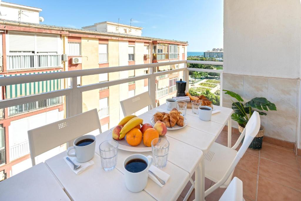 einen Tisch mit Essen auf dem Balkon in der Unterkunft CITY CENTER AND NEXT TO THE BEACH 3 BEDROOMs in Málaga