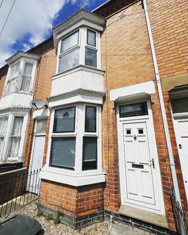 a brick house with a white door and windows at 2 bedroom house - Hopefield Road in Leicester