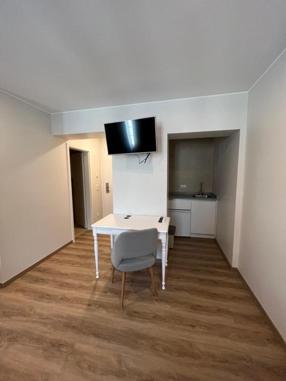 a room with a white table and a chair at Hotel Le Postillon in Echternach