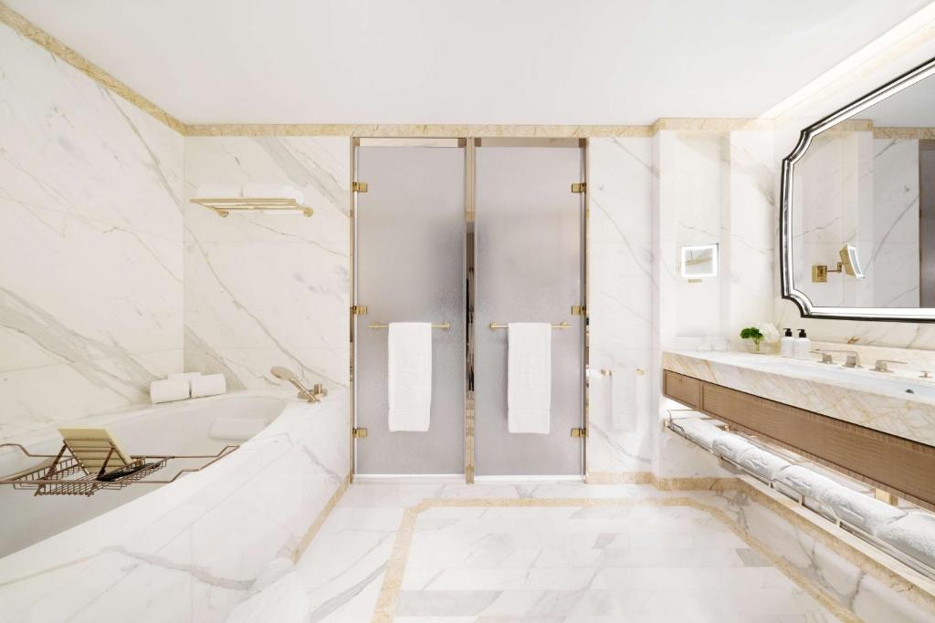 a white bathroom with a shower and a sink at Island Shangri-La, Hong Kong in Hong Kong