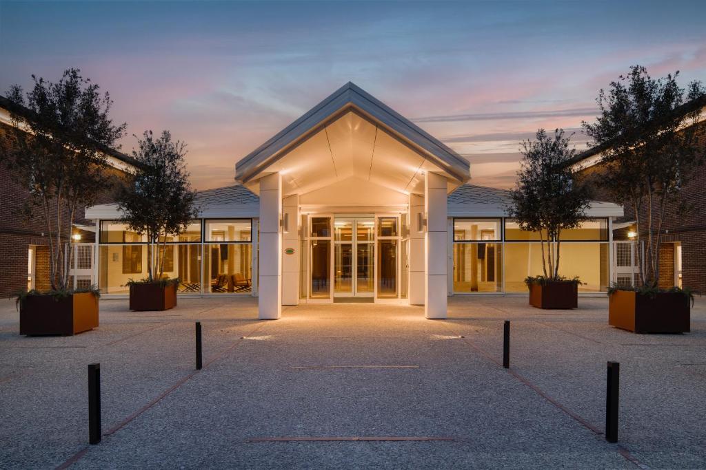 un edificio de oficinas con una fachada iluminada en UNAHOTELS Bologna San Lazzaro, en San Lazzaro di Savena