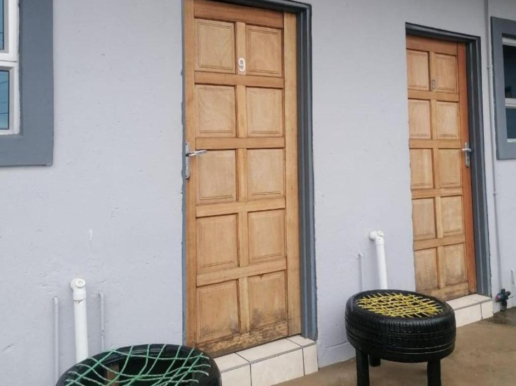 a pair of stools sitting in front of a door at Zithei Lodge in Lombardskop Settlement