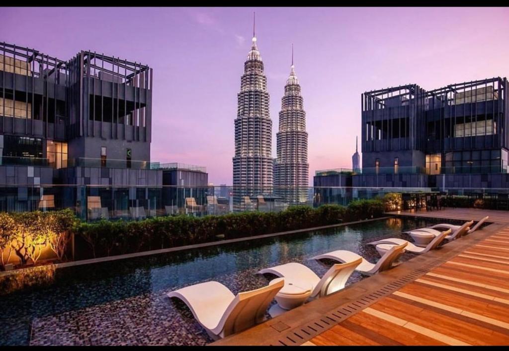 a row of lounge chairs on a building with the petronas towers at The Moods - Star Residence in Kuala Lumpur