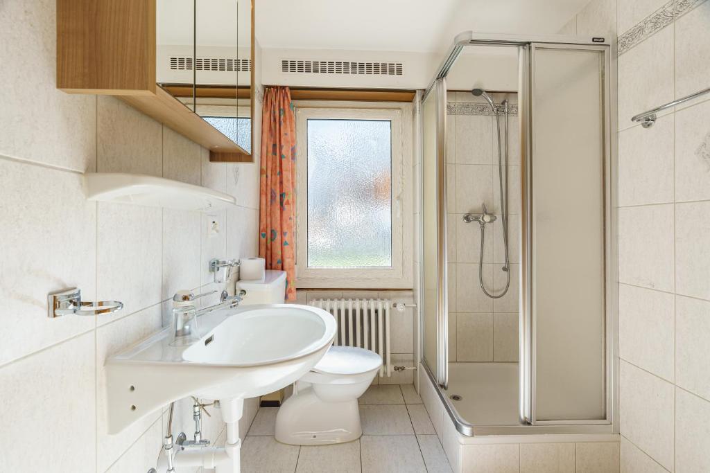 a bathroom with a sink and a toilet and a shower at Haus Alfa in Saas-Fee