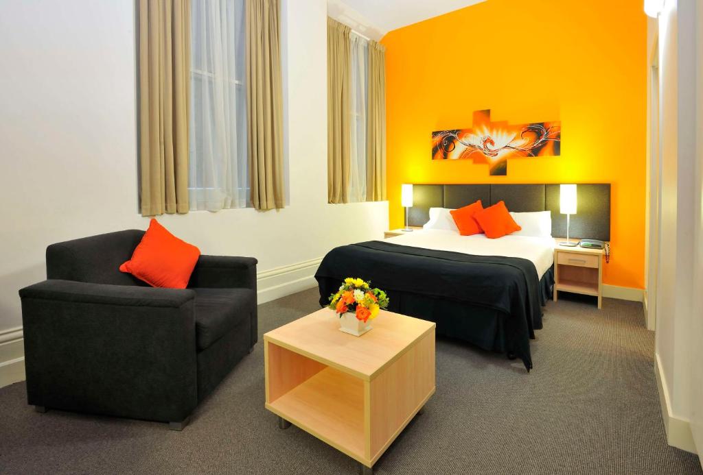 a hotel room with a bed and a chair at Metro Apartments On Bank Place in Melbourne