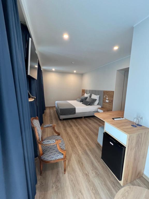 a bedroom with a bed and a table and a chair at Hotel Le Postillon in Echternach
