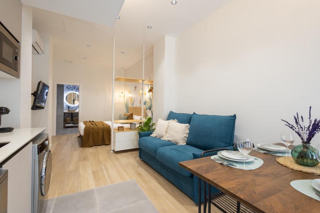 a living room with a blue couch and a table at FLORIT FLATS - The Green Apartments in Valencia