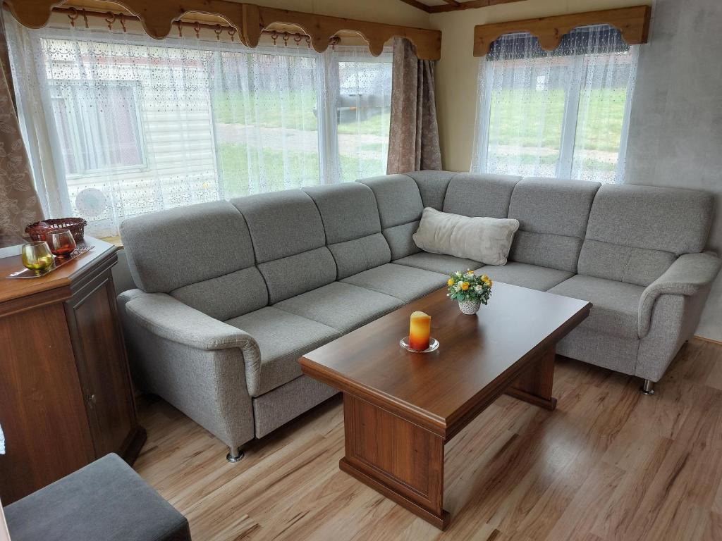 a living room with a couch and a coffee table at Mobilní dům Rimini a Monaco v kempu ve Výrovicích in Výrovice