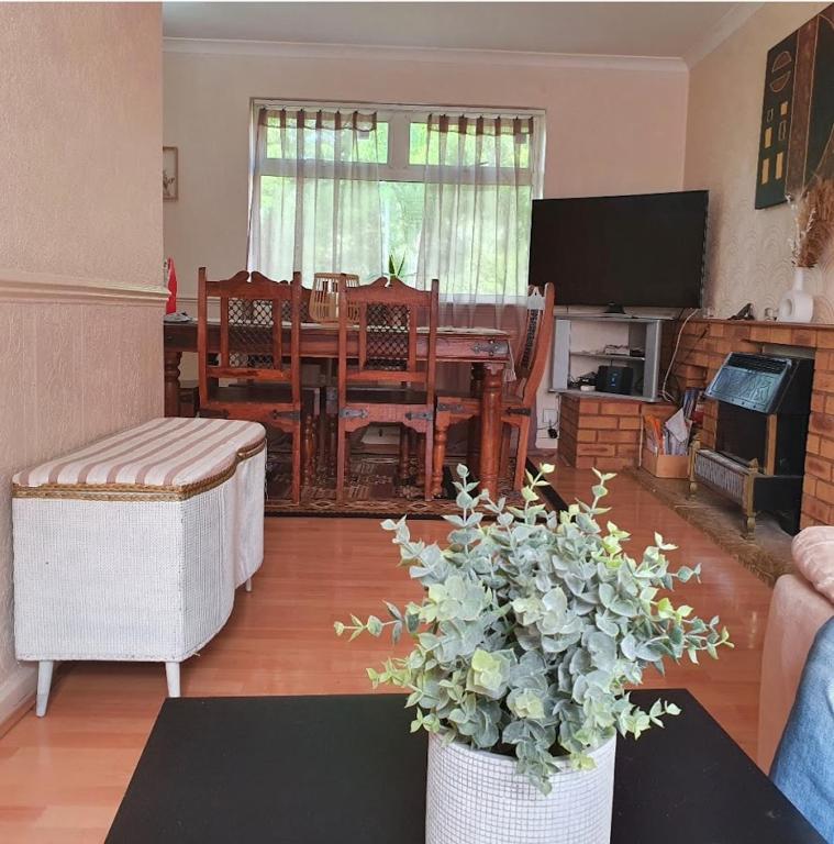 a living room with a table and a dining room at Alex's place in Hinckley