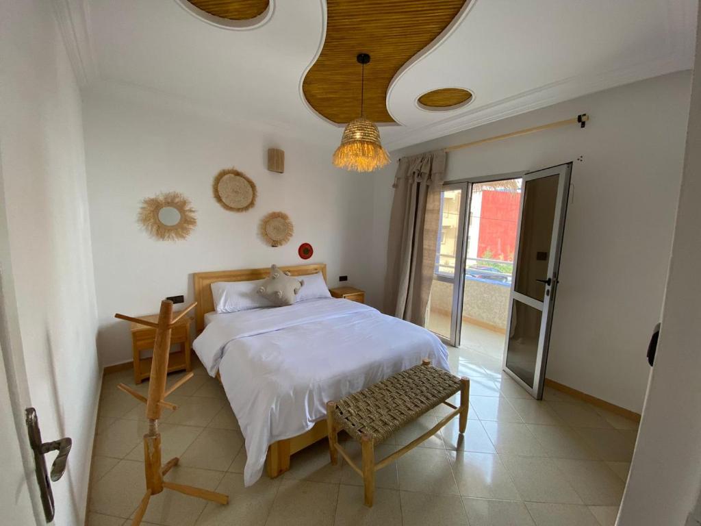 a bedroom with a bed and a chandelier at West coast surf house in Imsouane