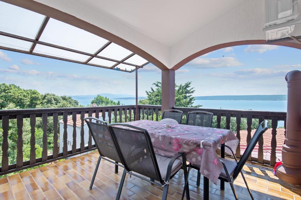 una mesa y sillas en un balcón con vistas al océano en Pansion Adria Haus, en Posedarje