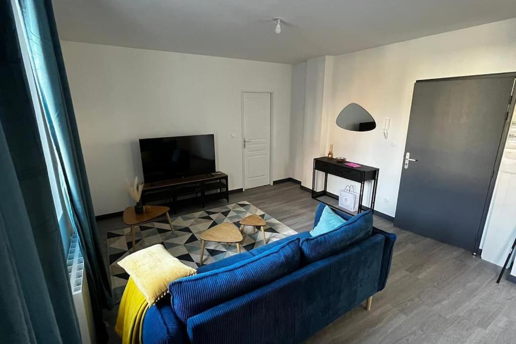uma sala de estar com um sofá azul e uma televisão em Appartement f2 Résidence Nassau em Beauvais
