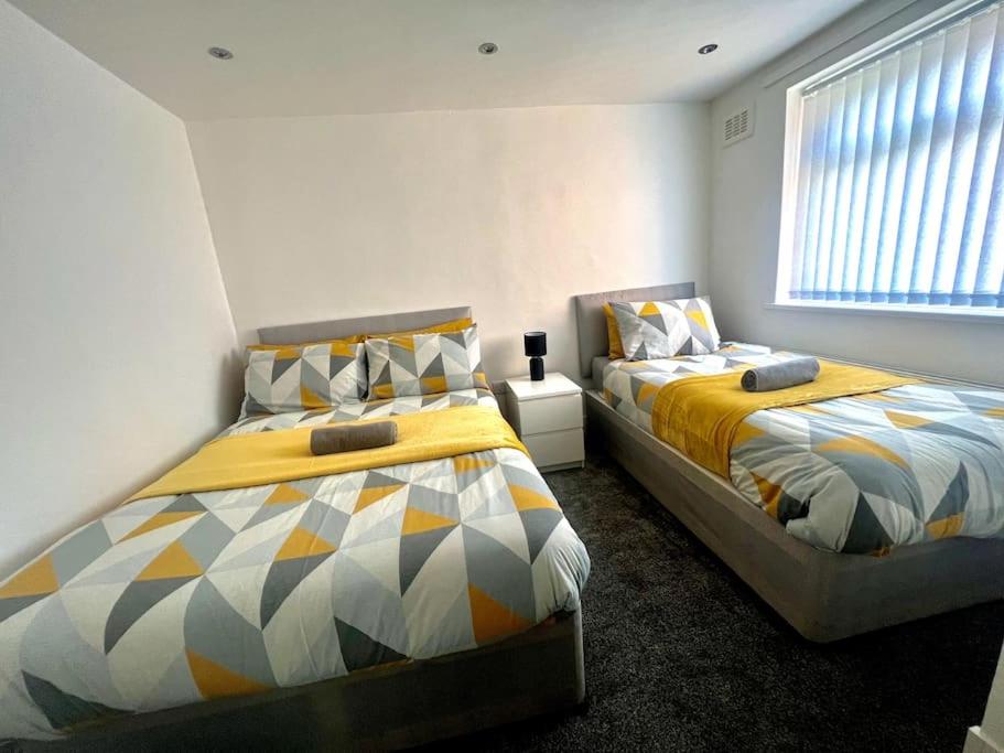 two beds sitting next to each other in a bedroom at Modern 4 Bed - 10 mins to centre in Liverpool