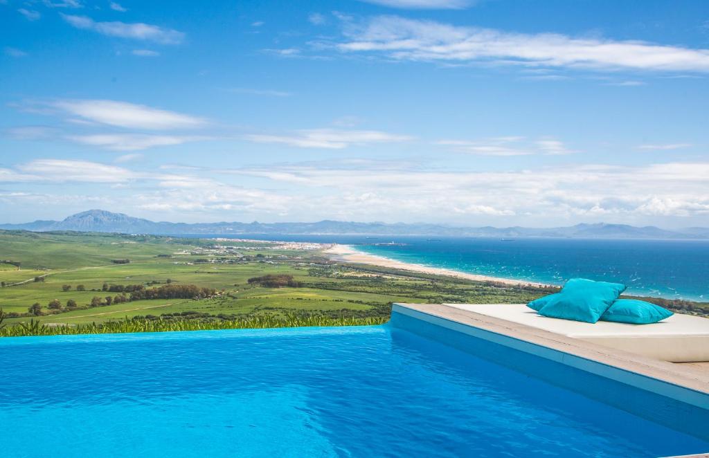 a infinity pool with a view of the ocean at Villa Tarifa Lodge in Tarifa