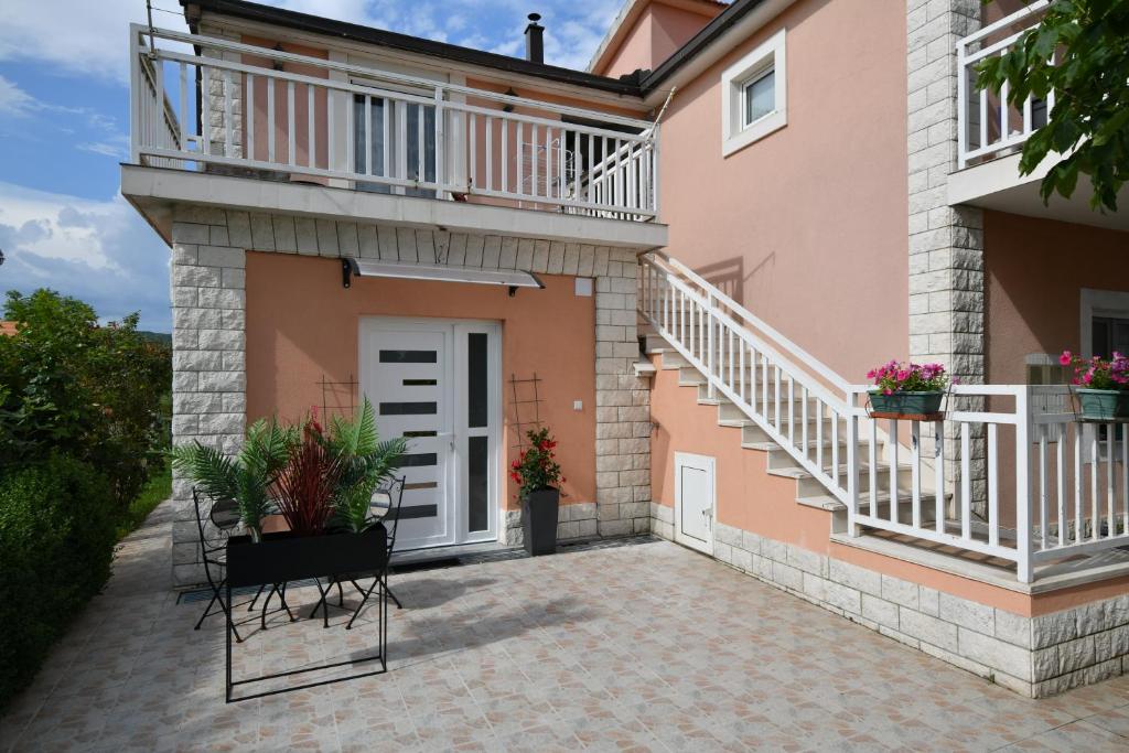 a house with a balcony and a patio at Palomino apartment in Sinj