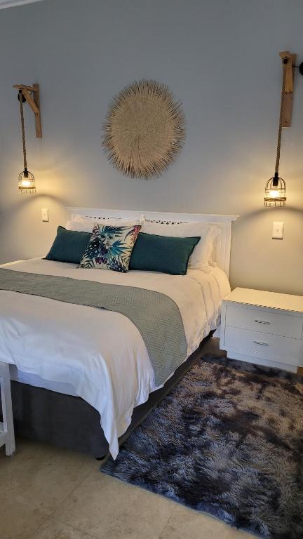 1 dormitorio con cama y espejo en la pared en Pelican Cottage - 800m from Beach & Yacht School en Hout Bay