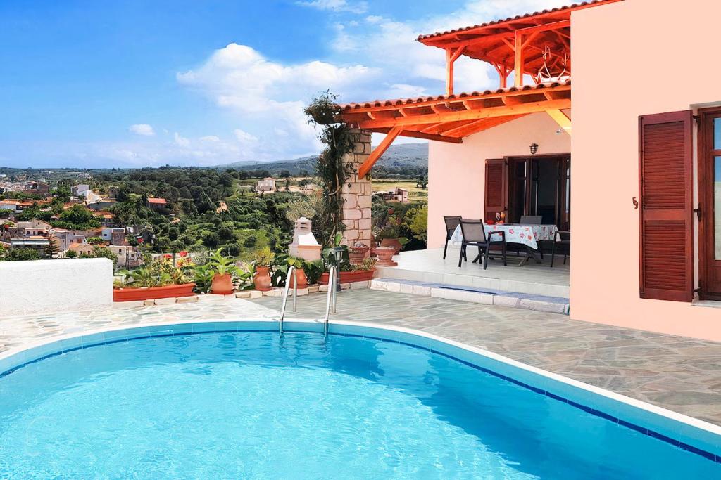 uma piscina em frente a uma casa em Villa Sunset with stunning sea view, kids area and hammocks on roof terrace em Agia Triada