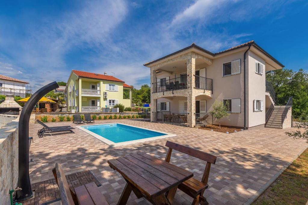 a backyard with a pool and a house at Apartman Sandra in Malinska