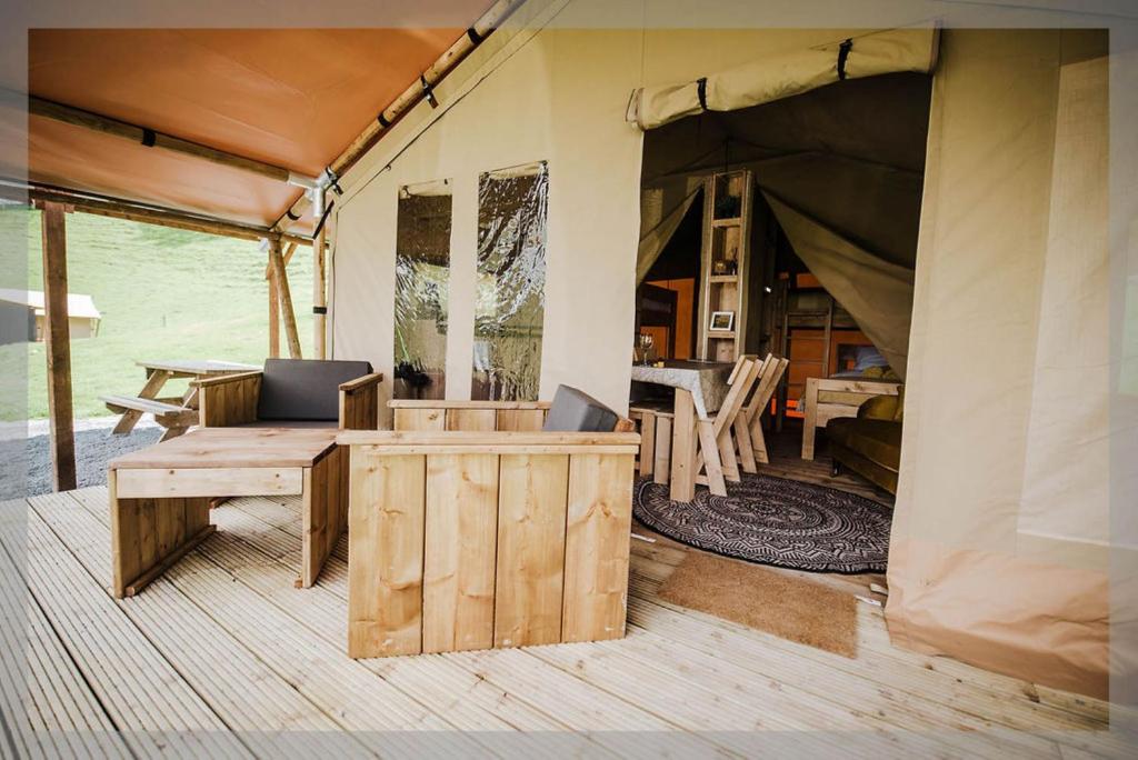 拉尼德洛伊斯的住宿－Ty Llewelyn Glamping & Camping，带桌椅的帐篷客房