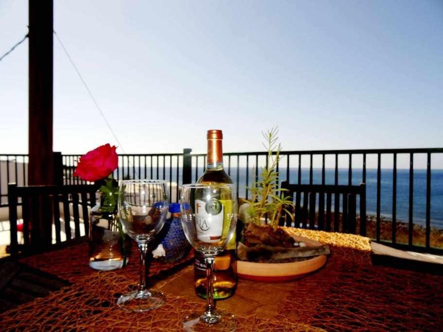 a table with two glasses and a bottle of wine at Apartamento Vacacional Pescaito en Playa Quemada in Playa Quemada