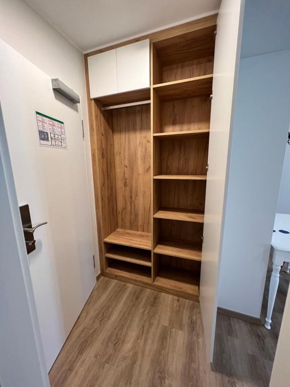 a walk in closet with wooden shelves at Hotel Le Postillon in Echternach