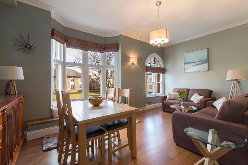 a living room with a table and a couch at Ambrose Apartments in Cheltenham