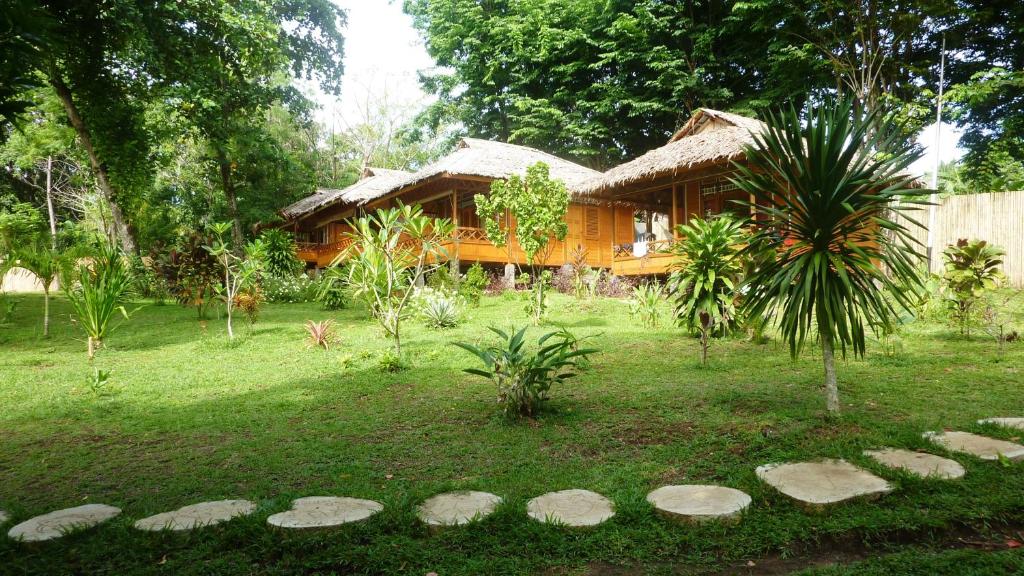 una casa en un patio con rocas delante en Raja Laut Dive Resort Bunaken, en Bunaken