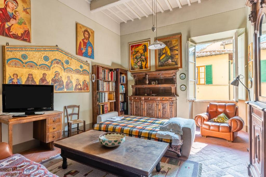 uma sala de estar com uma televisão e um sofá em La casa di Ida em Pescia