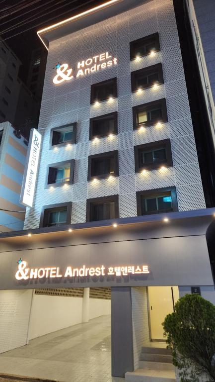 um hotel com uma placa em frente a um edifício em Hotel Andrest em Busan