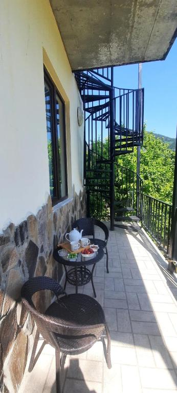 a patio with tables and chairs on a balcony at Guest House Bochora in Borjomi