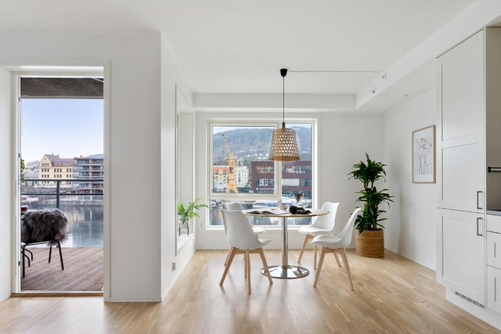 a kitchen and dining room with a table and chairs at BJØRVIKA APARTMENTS, Damsgård Area, Bergen city center in Bergen