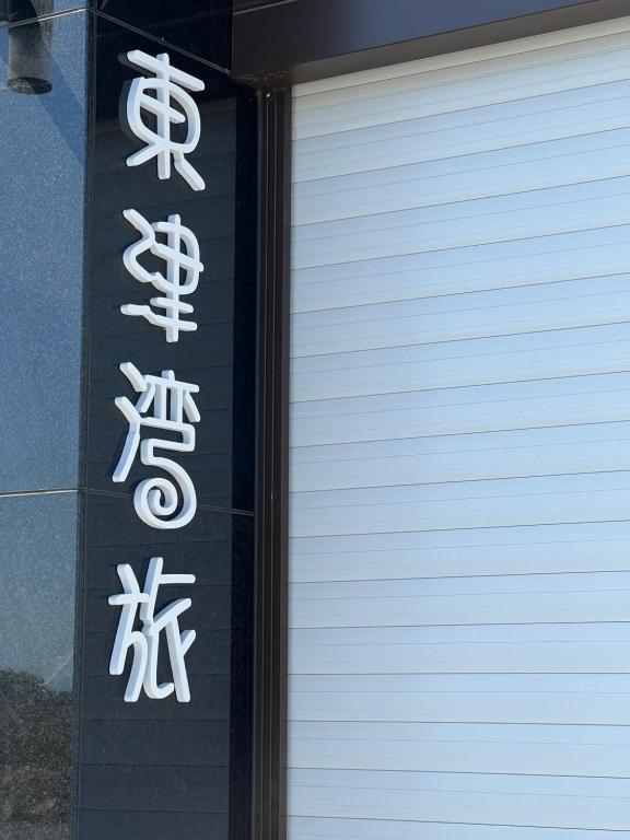 a sign with chinese writing on the side of a building at Dongjin Bay B&B in Donggang