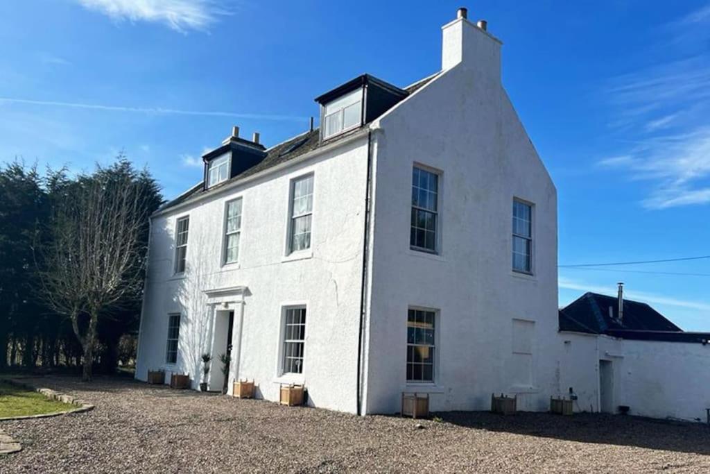 a large white house with a roof at Colzium Mansion House in Kirknewton