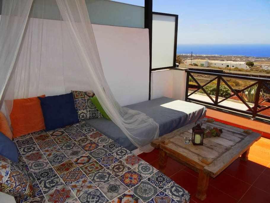 La AsomadaにあるApartamento deluxe Betancortのベッド、テーブル、窓が備わる客室です。