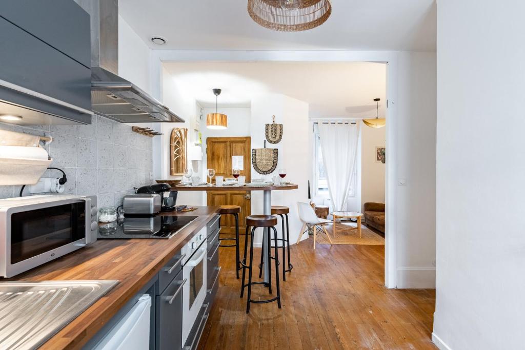 Il comprend une cuisine avec des murs blancs et du parquet. dans l'établissement Les Ducs de Bourgogne, à Dijon