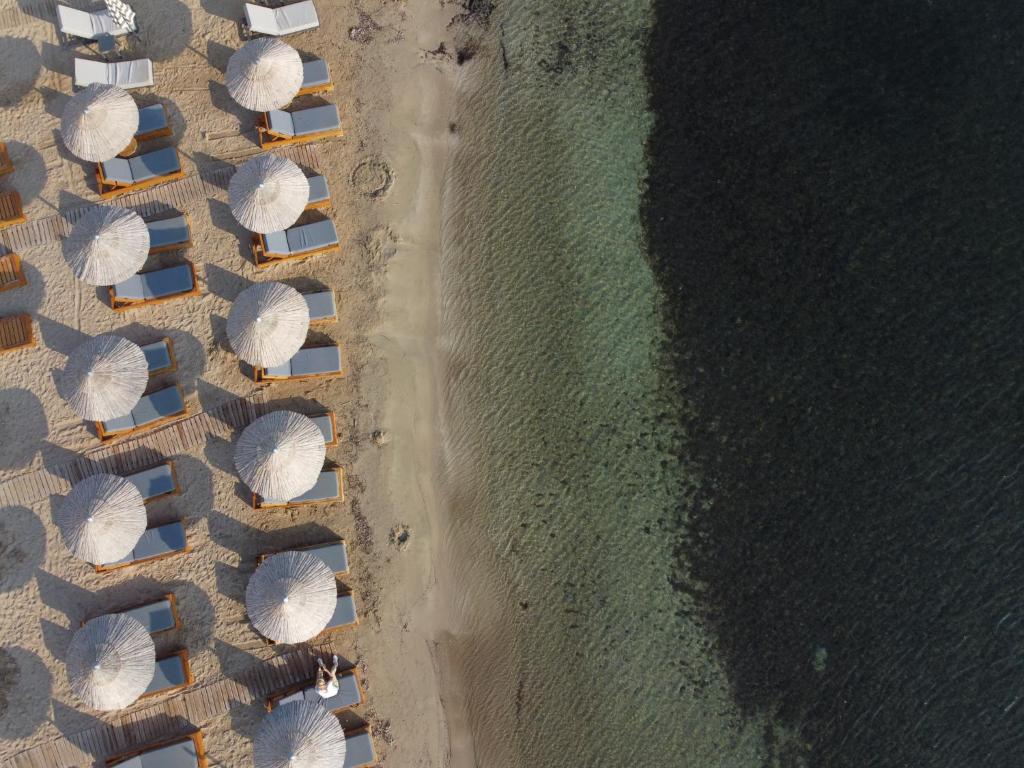 an overhead view of a beach with umbrellas and the ocean at Aktaion Beach Boutique Hotel & Spa in Skala