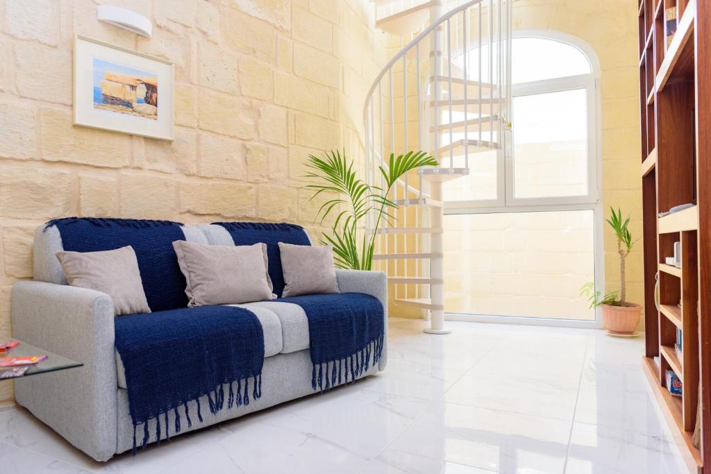 a living room with a blue couch and a window at Casa Deguara townhouse Rabat Malta in Rabat