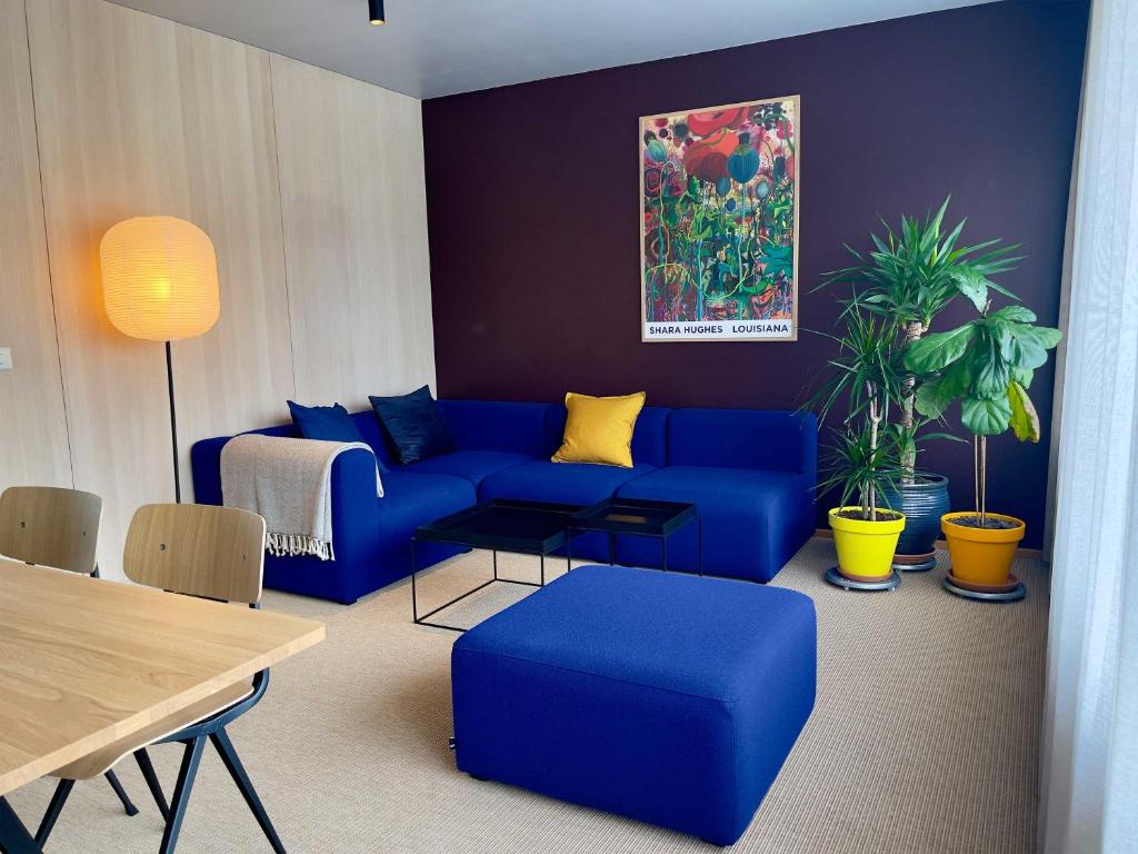 a living room with a blue couch and a table at Matkráin Apartments in Hveragerði