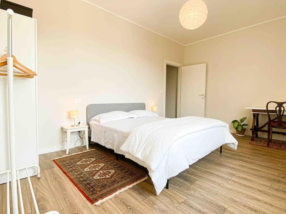 1 dormitorio con cama blanca y suelo de madera en CasaJila en Novi Ligure