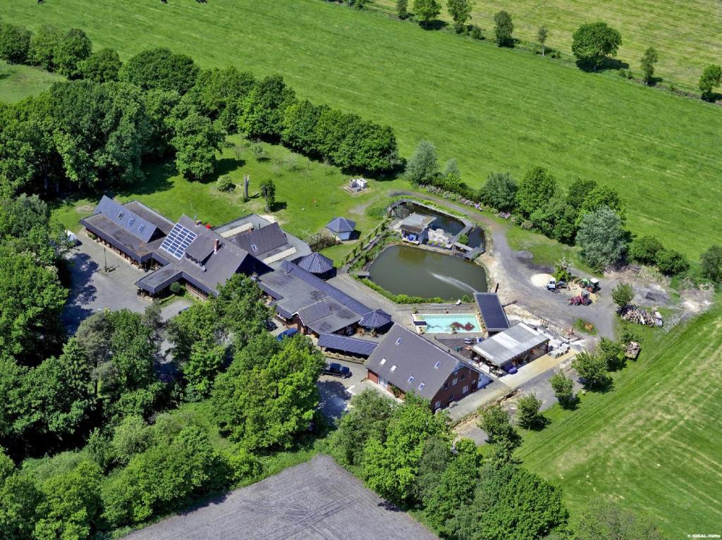 eine Luftansicht eines großen Hauses mit einem Teich in der Unterkunft IQBAL-Hütte (die Moorperle) in Beverstedt