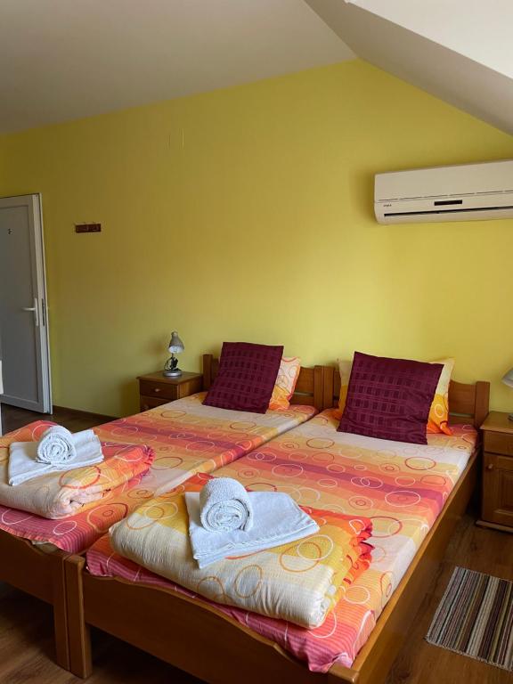 a bedroom with two beds with towels on them at Vila de lux in Bela Crkva