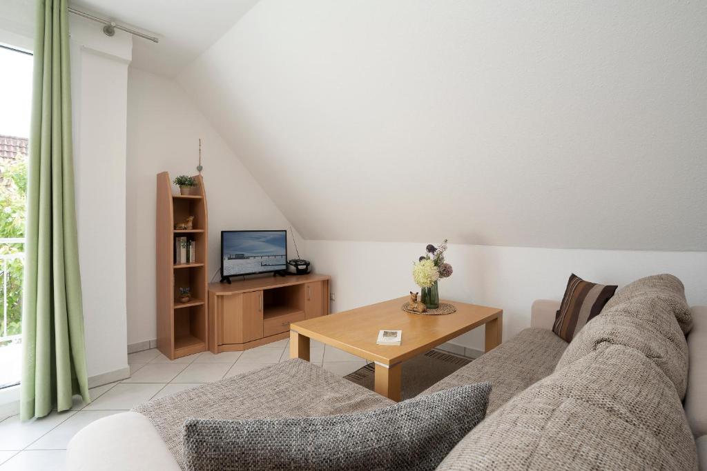 uma sala de estar com um sofá e uma mesa em Haus Waidmannsruh Hubertus em Kellenhusen
