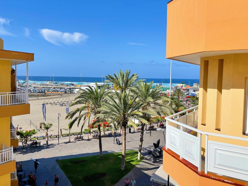 a view of a beach with palm trees and a building at Edificio Don Antonio in Los Cristianos