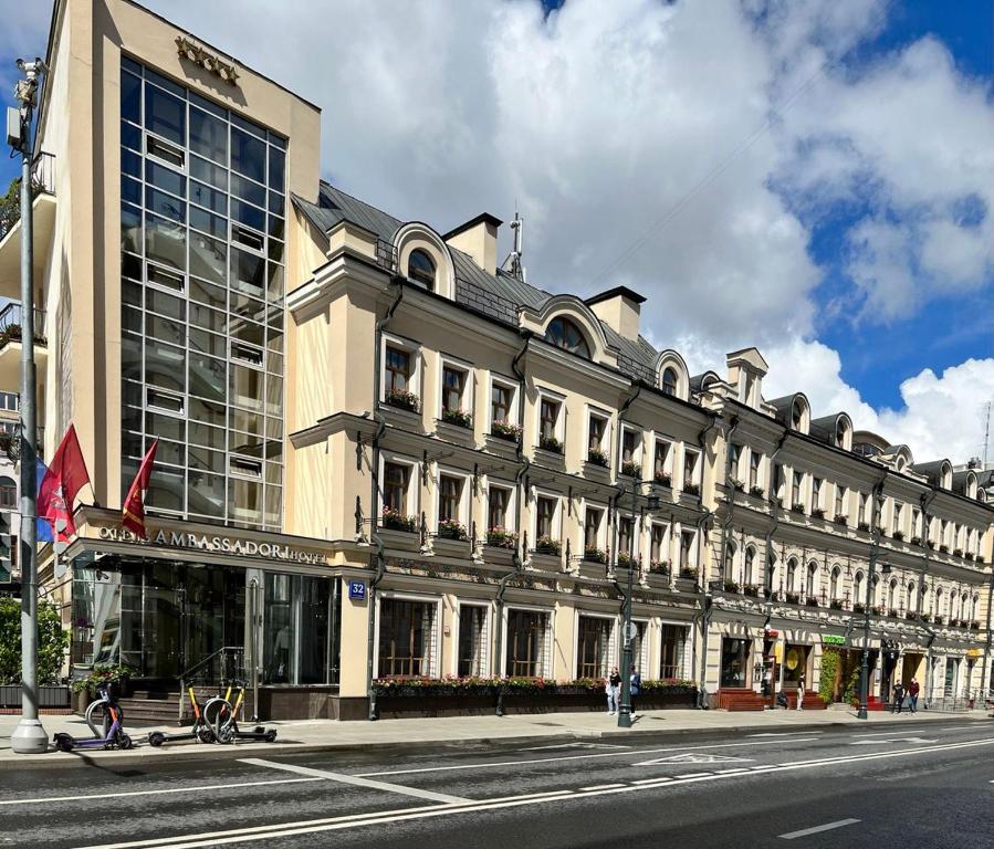 un gran edificio en una calle de la ciudad frente a un edificio en BOUTIQUE HOTEL AMBASSADORI MOSCOW, en Moscú