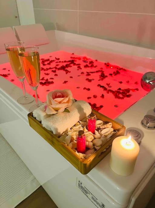 une table avec une bougie et des pétales de rose rouge sur une table dans l'établissement (1) La suite des vignobles 3km de Beaune, à Vignoles