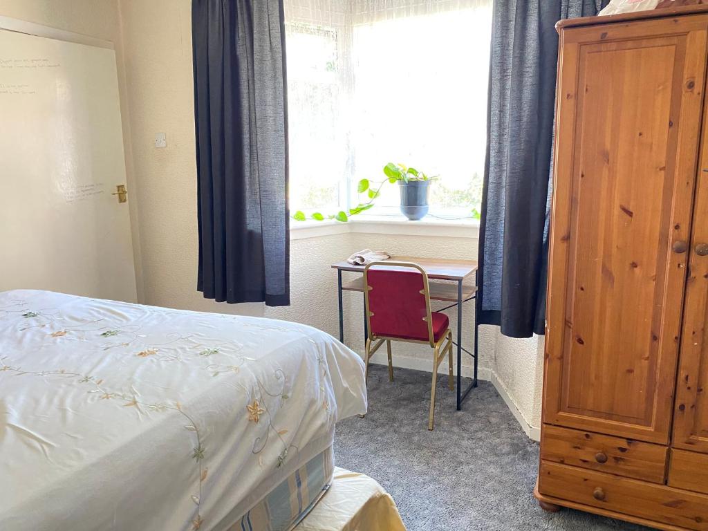 a bedroom with a bed and a table and a window at 132 in Bushbury