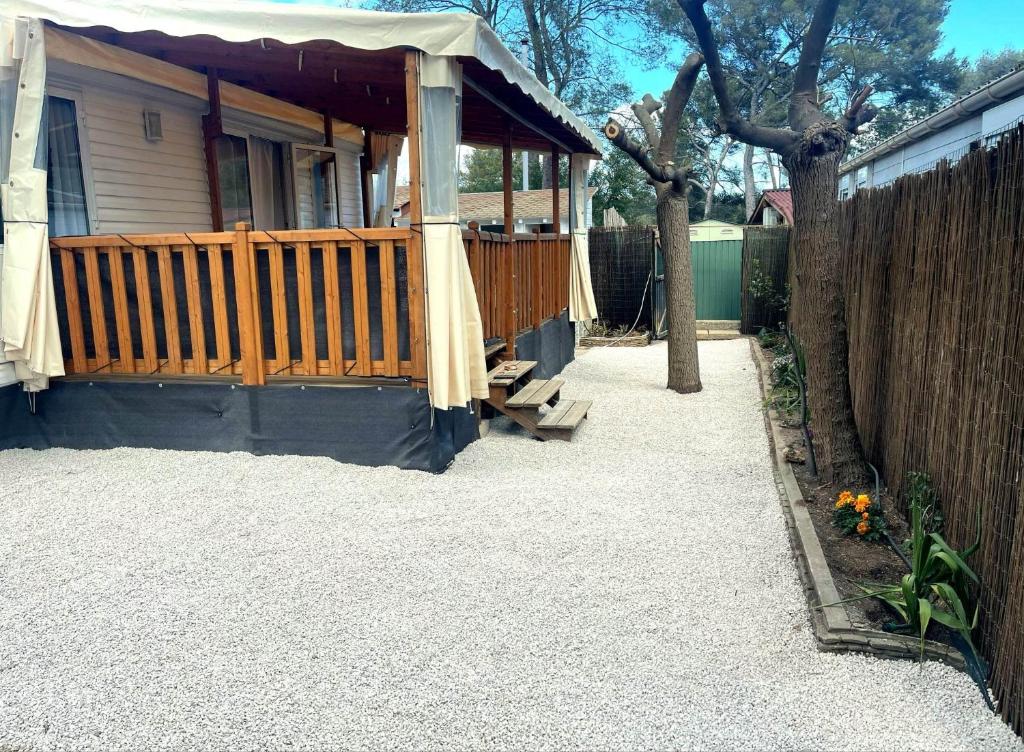 une maison avec une terrasse couverte en bois et une clôture dans l'établissement hakuna matata, à La Ciotat